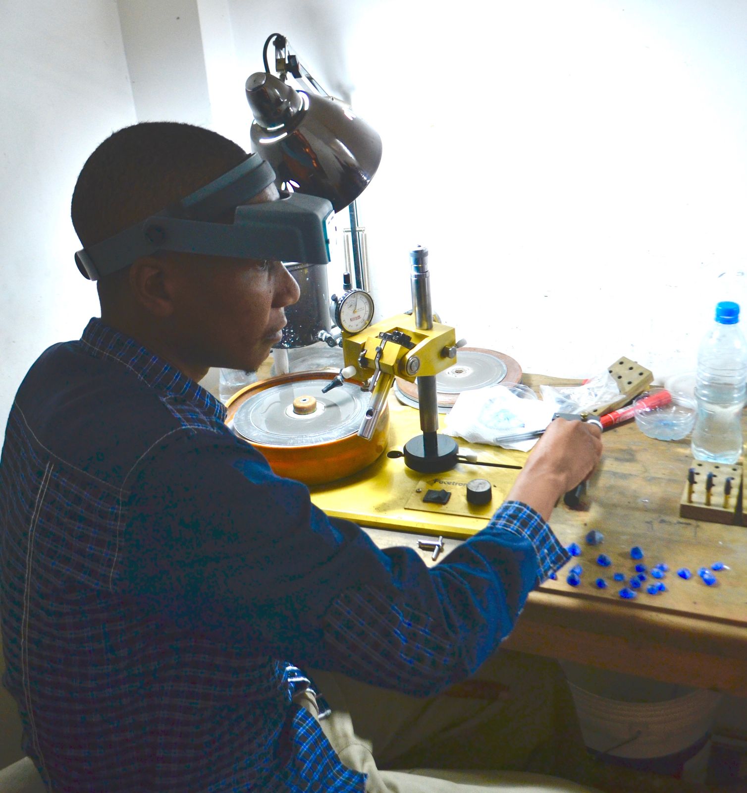 A gemstone cutter bringing out the colour in a rough tanzanite stone